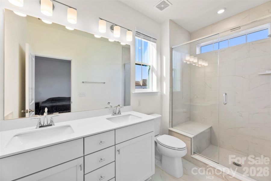 Primary Bath with dual sinks, Walk in shower and seat, plenty of natual light