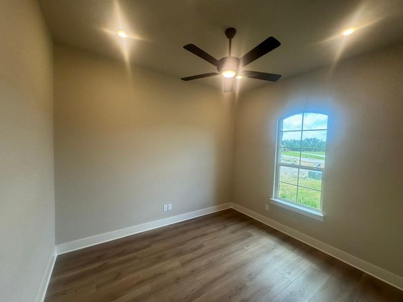 Room featuring wood-finish flooring, recessed lighting, and a ceiling fan with integrated lighting