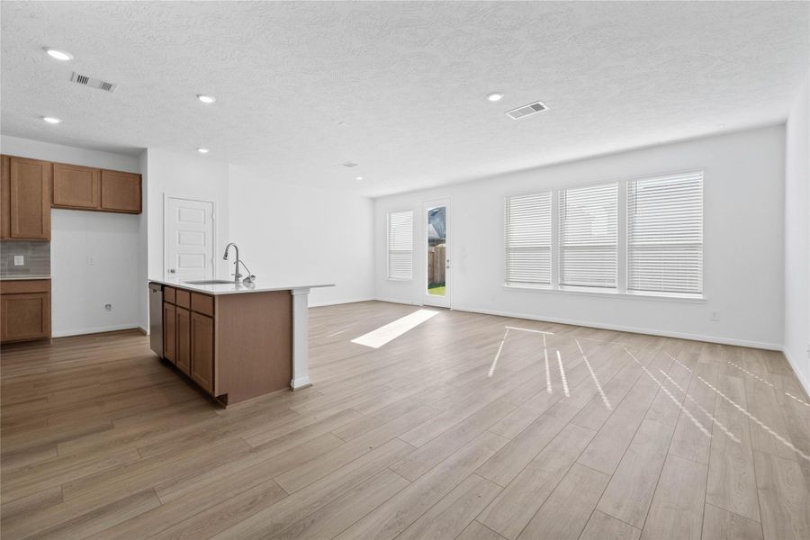 Flooded with natural light from large windows and a patio door, the Great Room feels bright and airy. Recessed lighting adds to the welcoming atmosphere, perfect for gathering with family and guests.