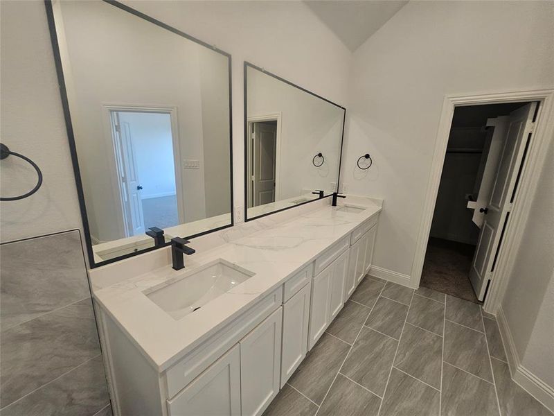 Bathroom featuring vanity and lofted ceiling