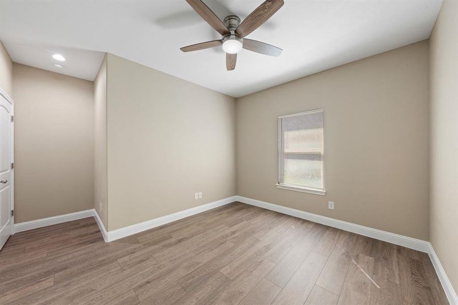 Unfurnished room featuring a ceiling fan, light wood-style flooring, and baseboards