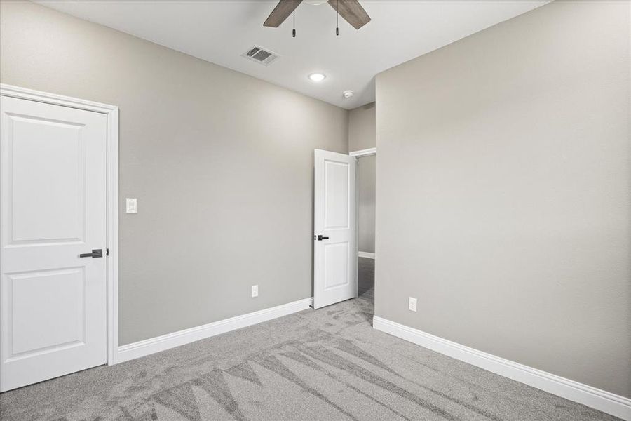 2nd bedroom featuring light carpet and ceiling fan