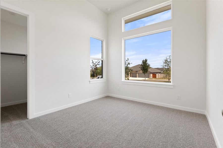 Unfurnished bedroom featuring carpet floors and a spacious closet
