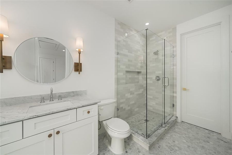 Bathroom featuring a white vanity with a marble countertop, an oval mirror, and wall-mounted sconces