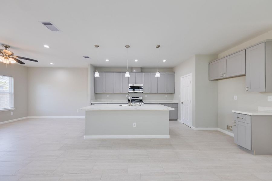The functional kitchen island features a sleek integrated sink, creating an ideal social hub for cooking and effortless entertaining.