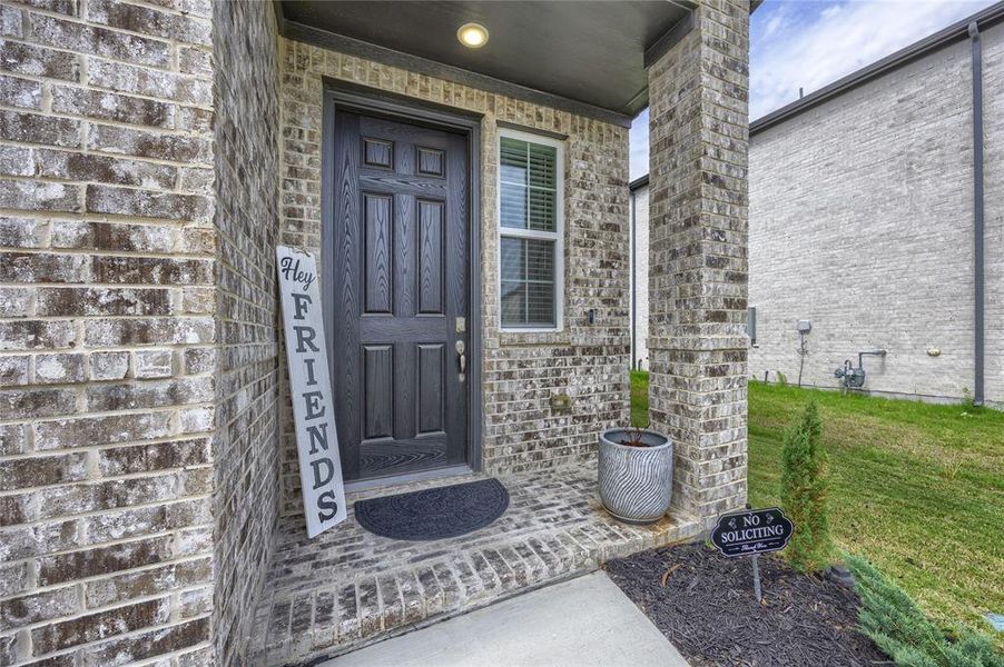 This inviting front entry features a charming, covered porch with brick pillars and a beautiful accent window that lets in natural light. The spacious entryway provides ample room for a welcoming front mat and decorative planters, creating excellent curb appeal.