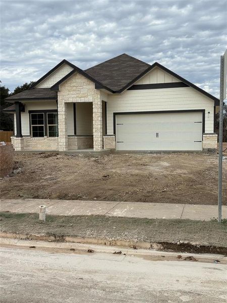 Single story home featuring stone siding, driveway, a garage, and covered porch Single story home featuring stone siding, driveway, a garage, and covered porch