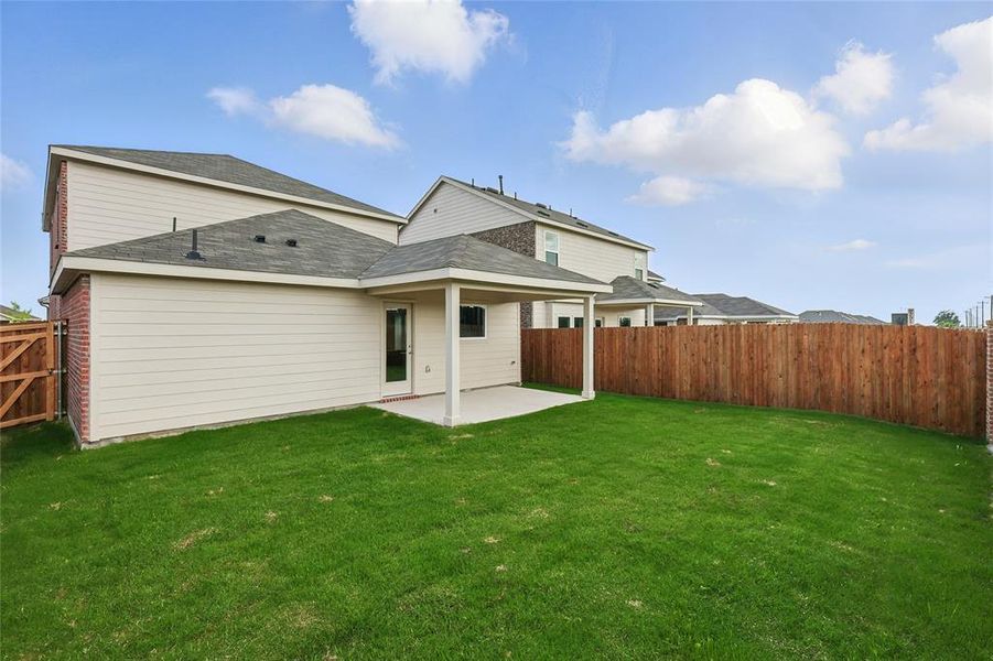 Rear view of house featuring a patio, roof with shingles, and a fenced backyard