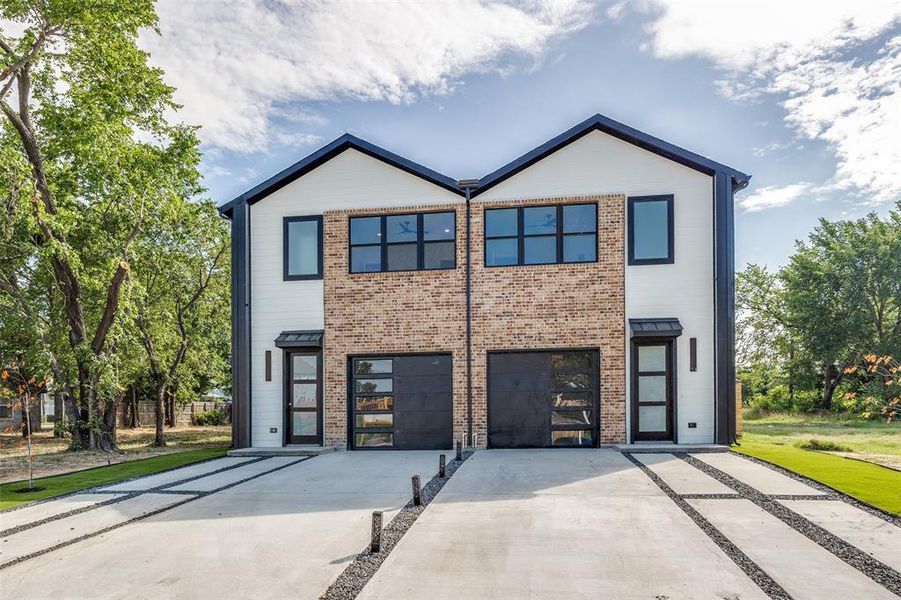 Contemporary house with an attached garage, driveway, and brick siding Contemporary house with an attached garage, driveway, and brick siding