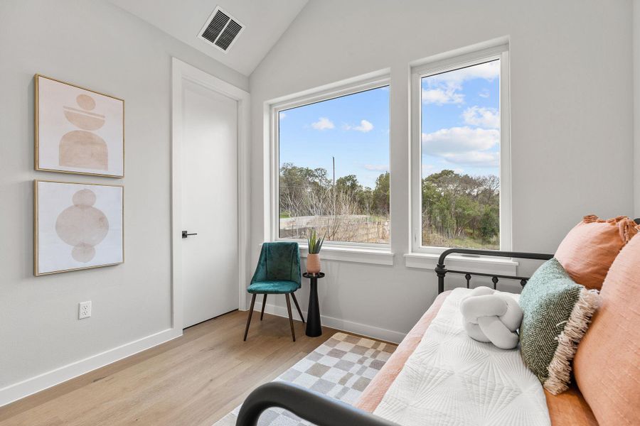 Sitting room featuring lofted ceiling, wood finished floors, visible vents, and baseboards