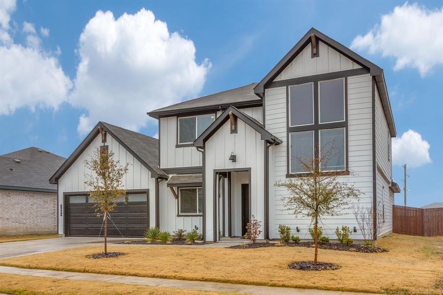 Modern inspired farmhouse with a garage and a front lawn