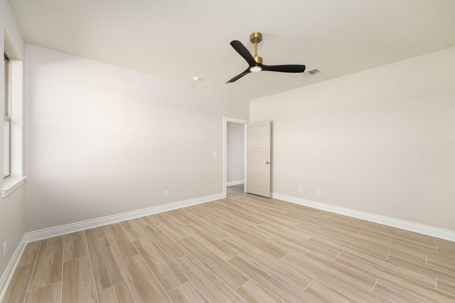 Empty room featuring wood finish floors and a ceiling fan Empty room featuring wood finish floors and a ceiling fan