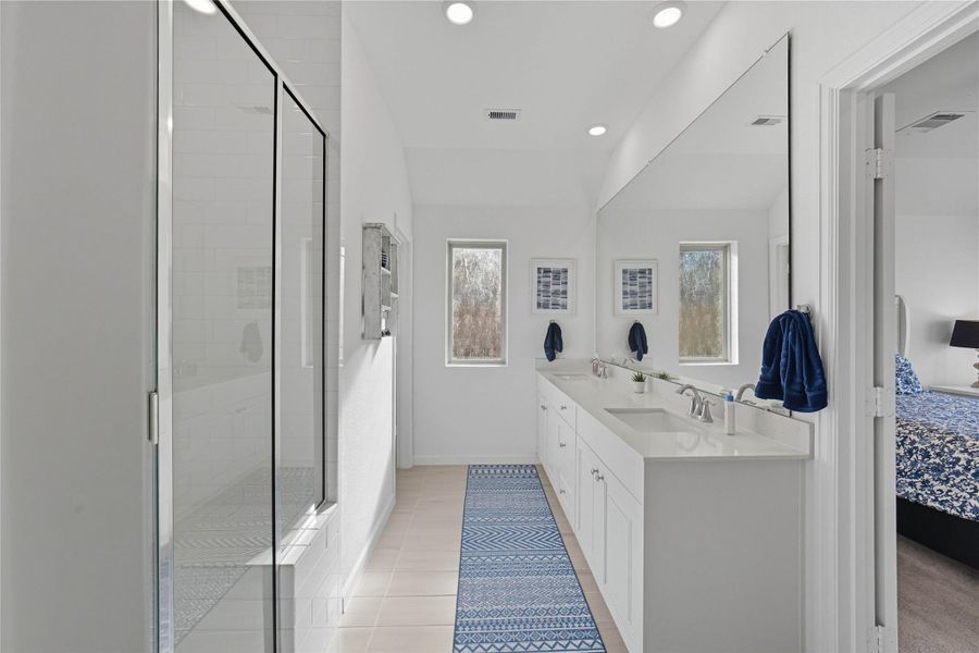 The modern master bathroom features a spacious double vanity with a large mirror, a glass-enclosed shower, and plenty of natural light. The modern master bathroom features a spacious double vanity with a large mirror, a glass-enclosed shower, and plenty of natural light.