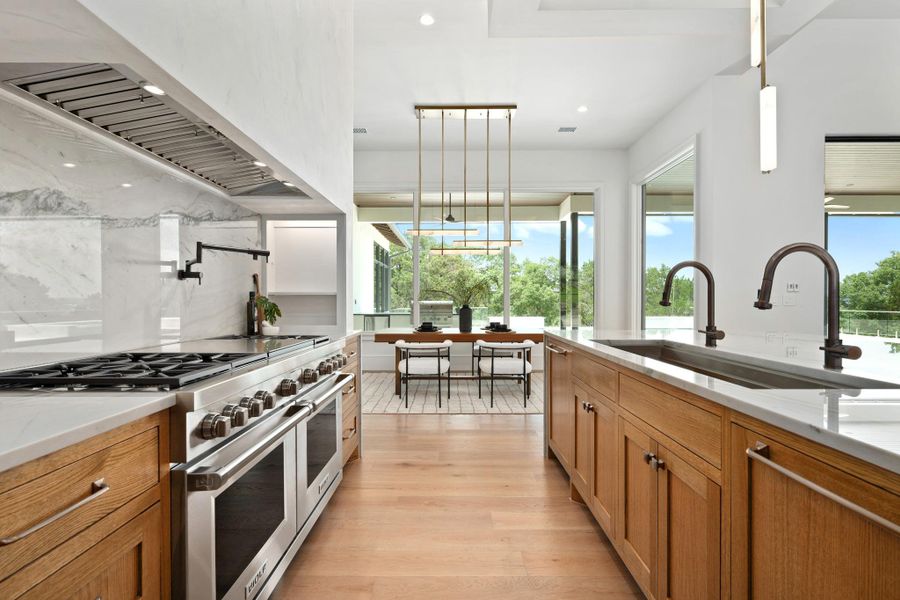 Culinary excellence meets scenic views in this bright, open-concept kitchen with premium appliances, including 60" Wolf Range.
