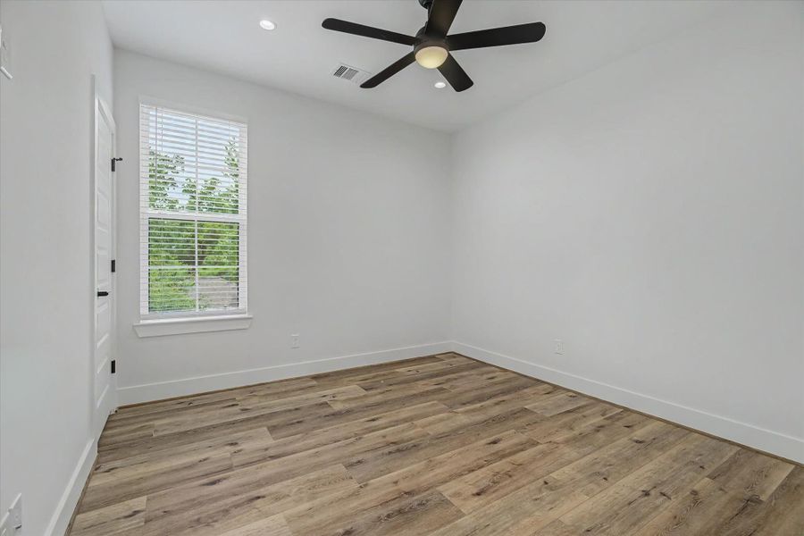 Spacious bedroom featuring recessed can lighting and a remote-controlled ceiling fan.