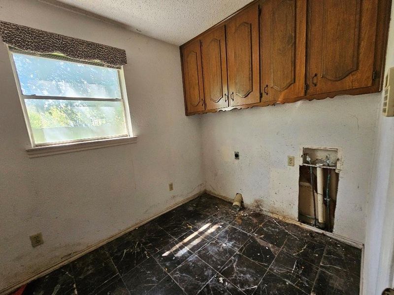 Laundry room with a textured ceiling, cabinet space, hookup for a washing machine, and hookup for an electric dryer Laundry room with a textured ceiling, cabinet space, hookup for a washing machine, and hookup for an electric dryer