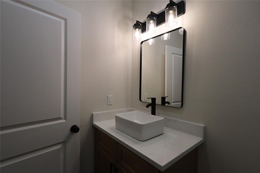 Bathroom featuring vanity and a textured wall