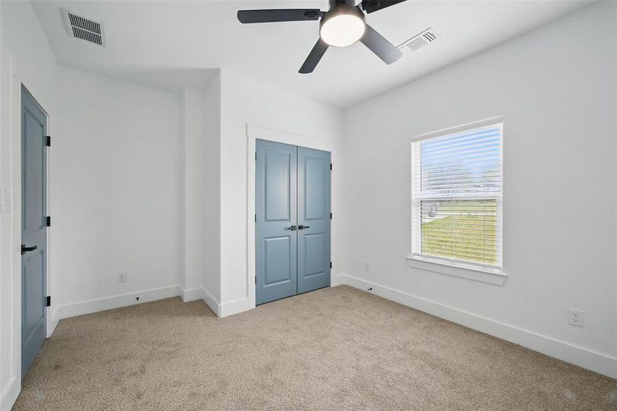 Unfurnished bedroom featuring light colored carpet, baseboards, and visible vents