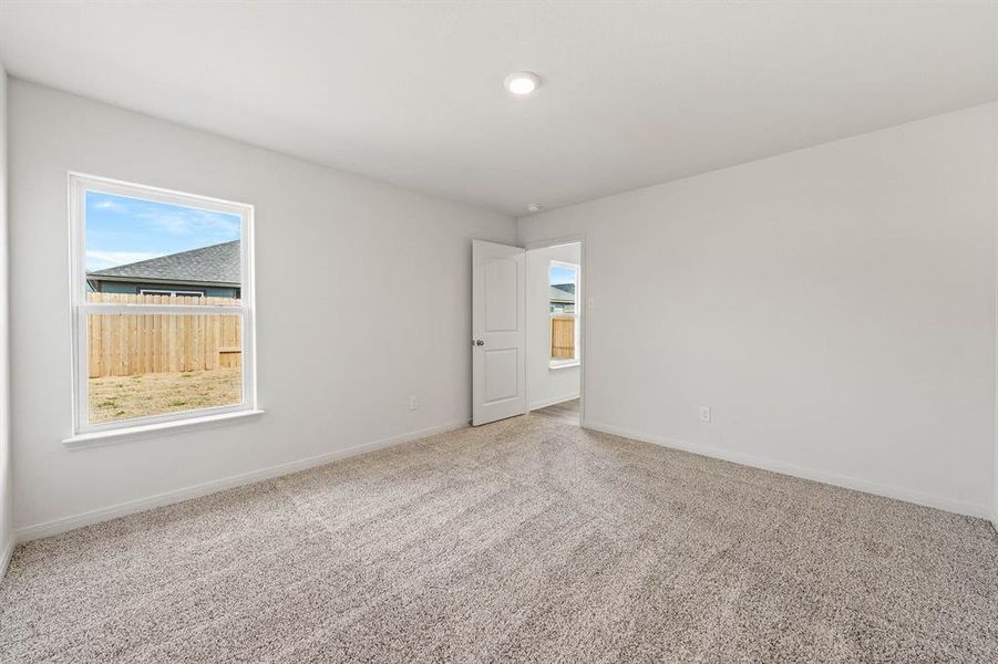 Spare room featuring plenty of natural light and light carpet