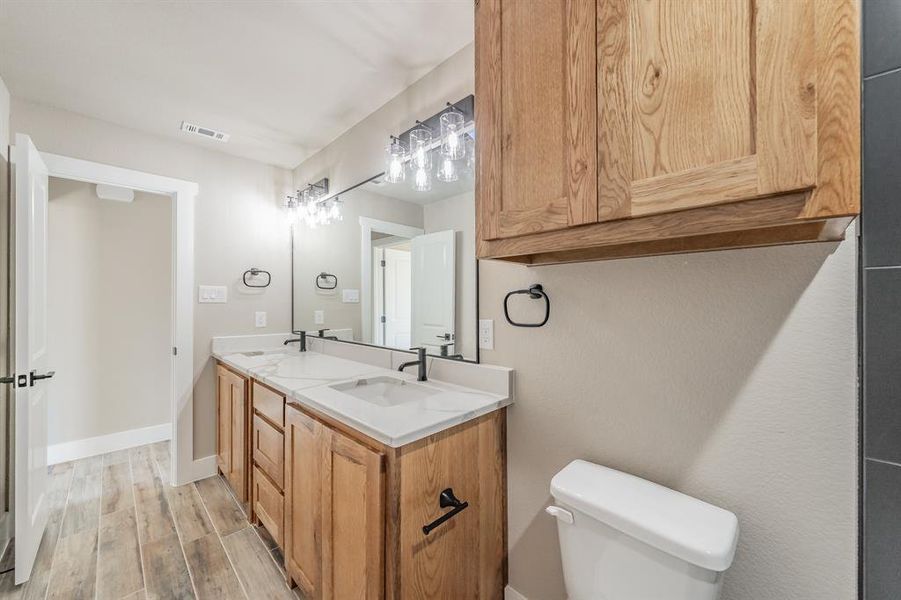 Bathroom featuring double vanity and light wood-style floors Bathroom featuring double vanity and light wood-style floors