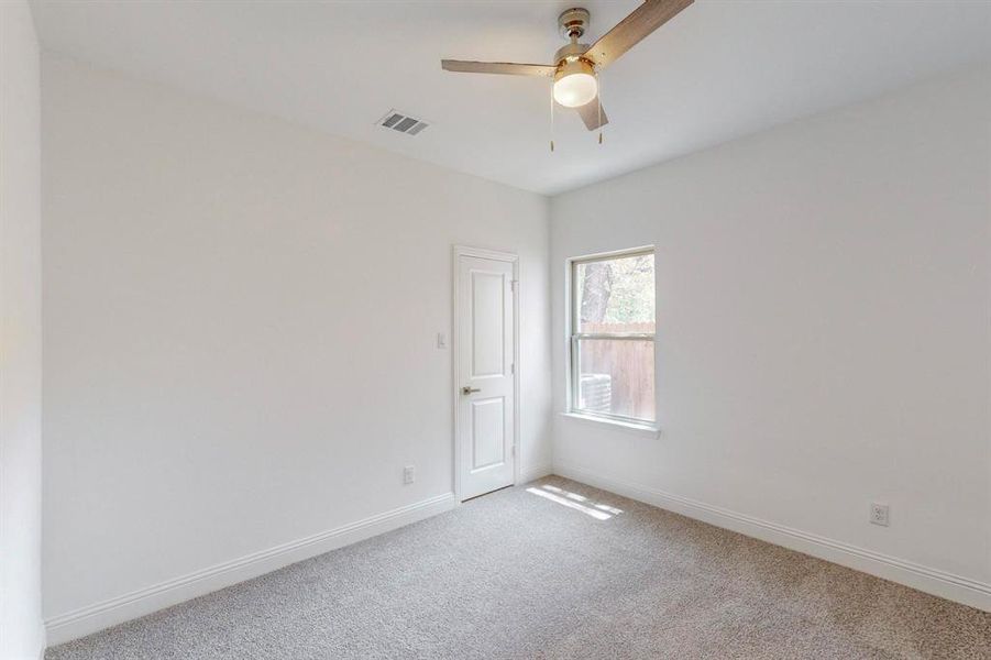 Carpeted empty room with ceiling fan