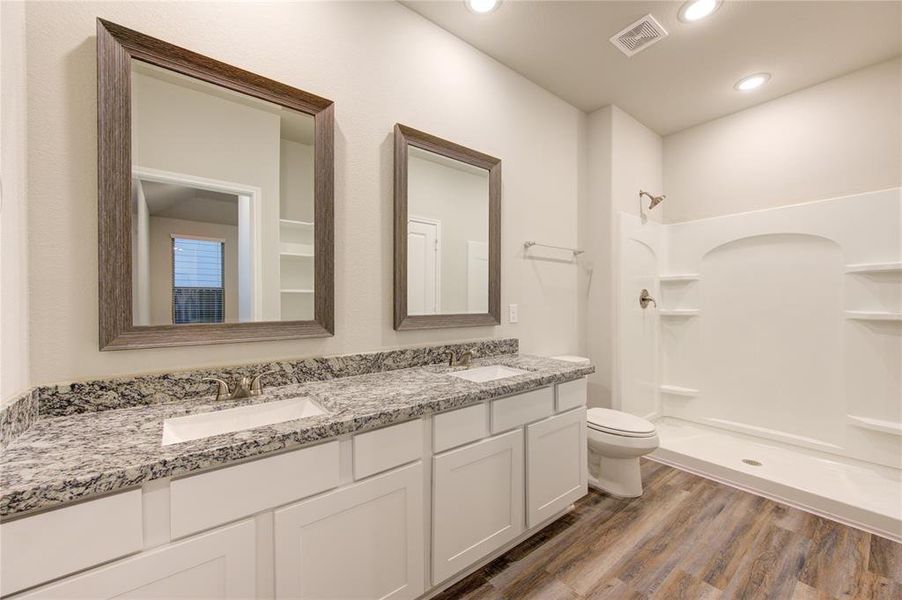 Double sinks, granite counters, framed mirrors, shelving- this master bath has everything!