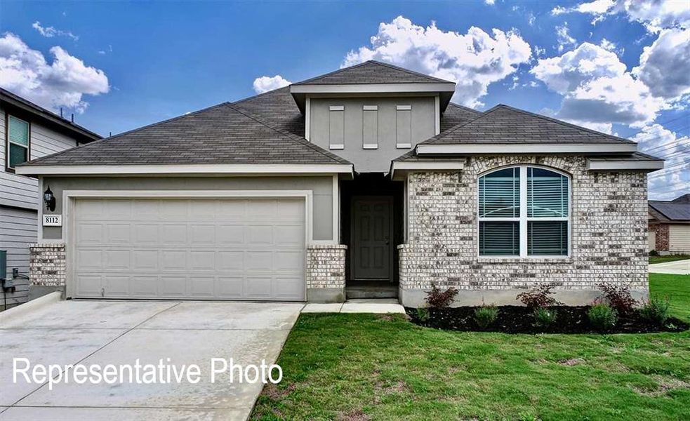 View of front of home featuring a front lawn and a garage