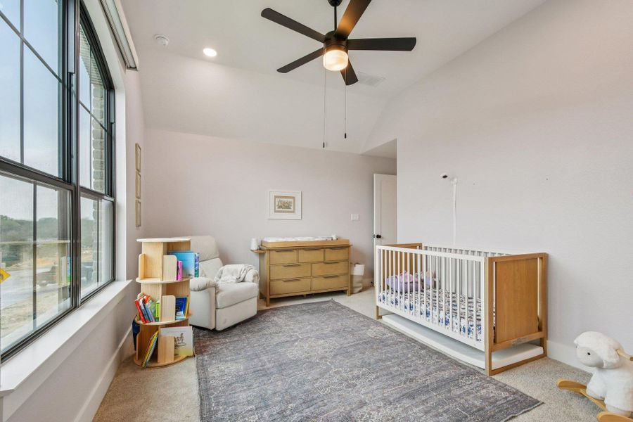 This room features a high vaulted ceiling, a ceiling fan with integrated lighting, and substantial windows with black frames This room features a high vaulted ceiling, a ceiling fan with integrated lighting, and substantial windows with black frames
