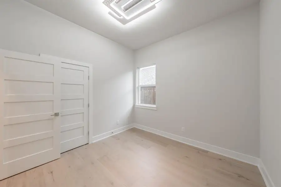 Unfurnished room with cooling unit and light wood-style flooring