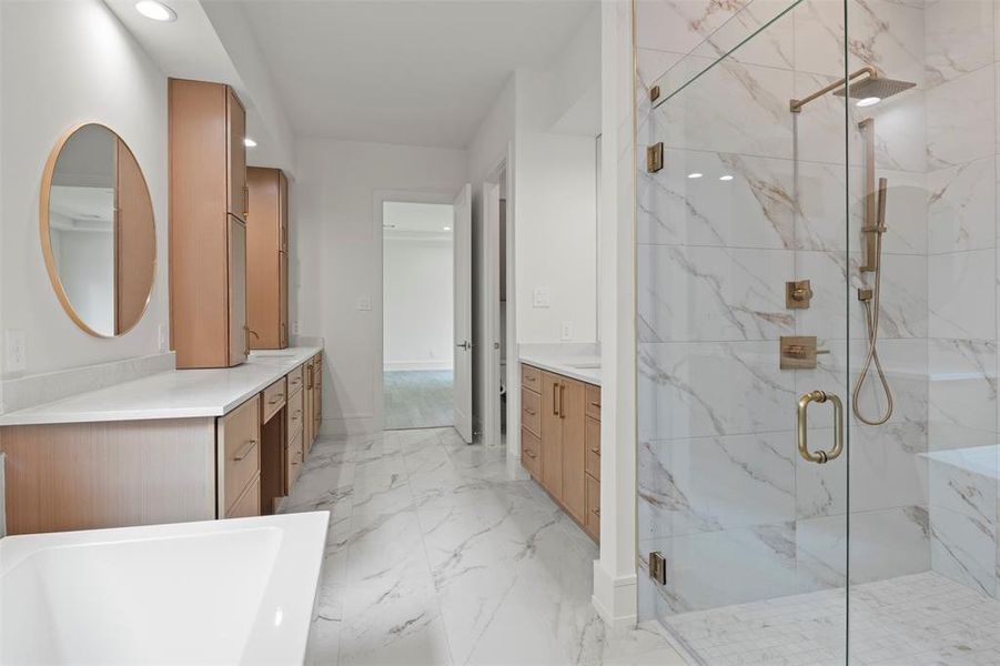 Full bath featuring a marble finish shower, a freestanding bath, vanity, recessed lighting, and light marble finish flooring Full bath featuring a marble finish shower, a freestanding bath, vanity, recessed lighting, and light marble finish flooring