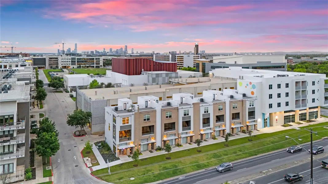 Contemporary townhome row featuring multi-story facades, large windows, and integrated street-level access
