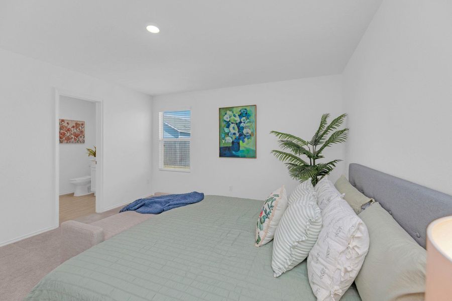 Carpeted bedroom with recessed lighting and ensuite bath