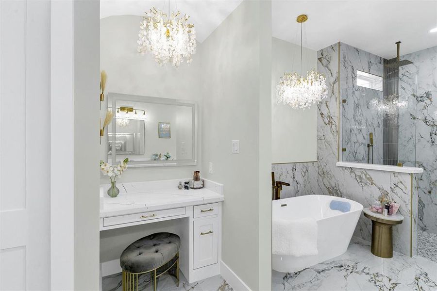 Bathroom featuring vanity, a notable chandelier, and separate shower and tub