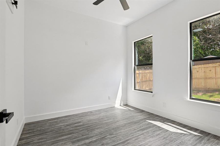 Unfurnished room featuring wood finished floors and baseboards Unfurnished room featuring wood finished floors and baseboards