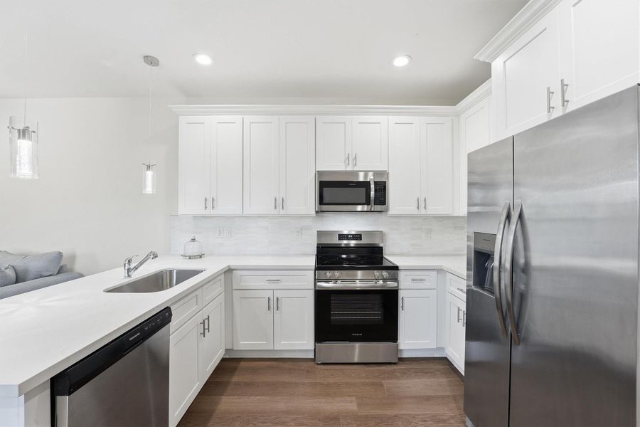 The kitchen offers abundant storage and prep space with tall cabinetry, quartz countertops, and a clean, modern finish that supports both everyday living and short-term rental use.