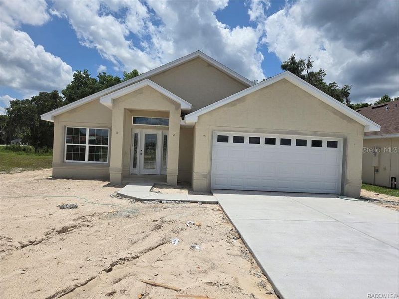 Front exterior of a new home in Wyld Palms, Inverness, FL, highlighting curb appeal (Image 1).