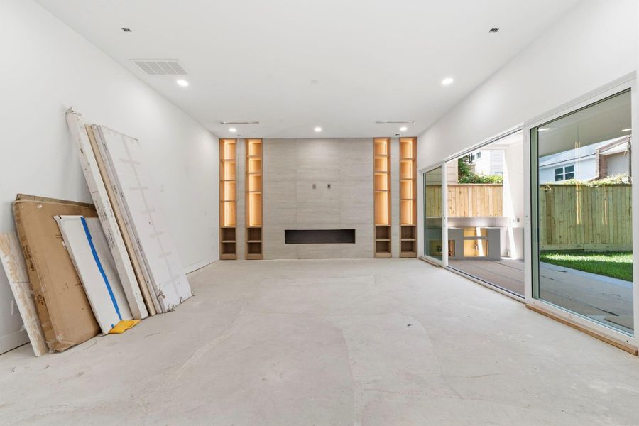 This photo showcases an alternative perspective of the primary living space, highlighting the warm tones and will be complete with white oak engineered wood flooring. The expansive, sliding glass doors seamlessly connect the interior to a covered patio, which will feature a fully integrated outdoor kitchen, perfect for entertaining. This photo showcases an alternative perspective of the primary living space, highlighting the warm tones and will be complete with white oak engineered wood flooring. The expansive, sliding glass doors seamlessly connect the interior to a covered patio, which will feature a fully integrated outdoor kitchen, perfect for entertaining.