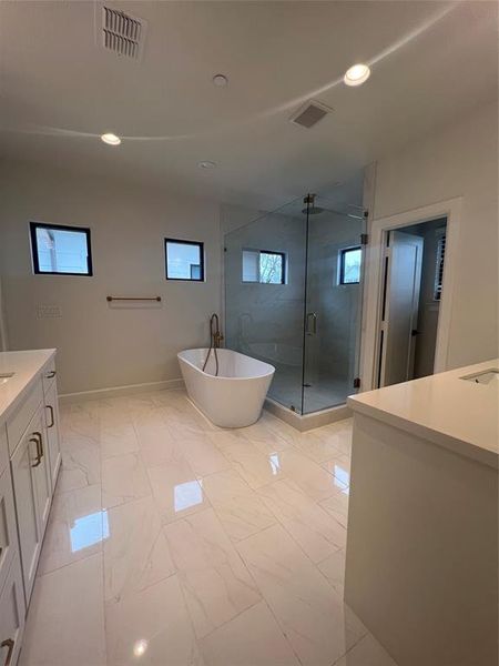 Bathroom featuring a shower with shower door, vanity, and tile flooring