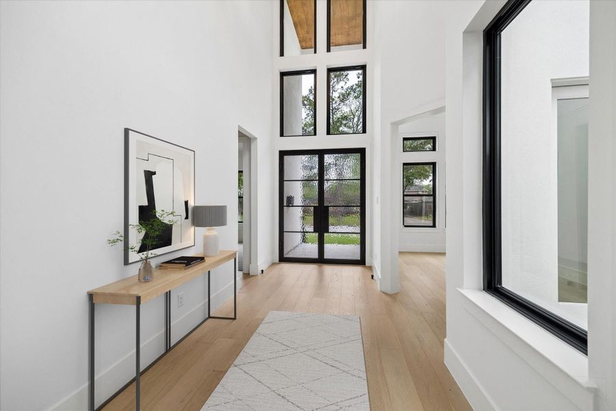 The opulent design of the full floor to ceiling glass sets an impressive stage at the 22 foot high Entry. The door to the left leads to the downstairs guest room (all interior doors are 8 foot) and the one to the right takes you to the privately located Study (or formal Living Room or kids' play room)