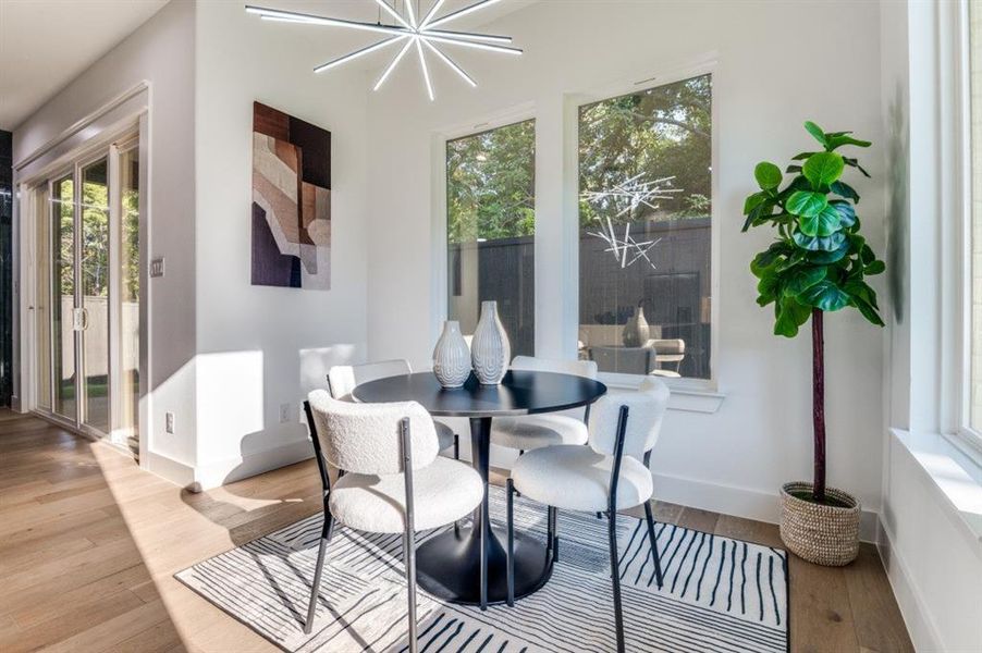 Dining space featuring healthy amount of natural light, a chandelier, and wood finished floors Dining space featuring healthy amount of natural light, a chandelier, and wood finished floors