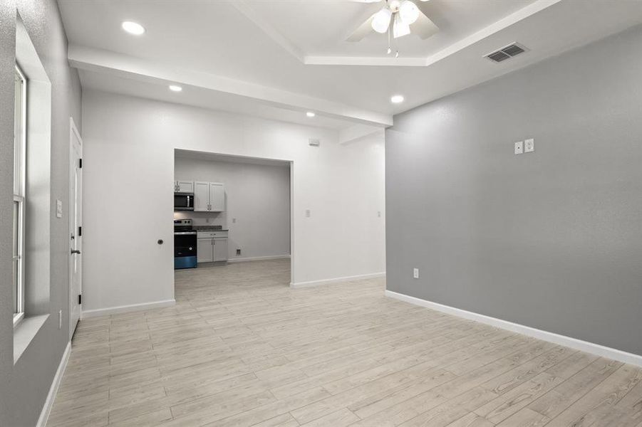 Empty room with a ceiling fan, recessed lighting, and light wood-style floors