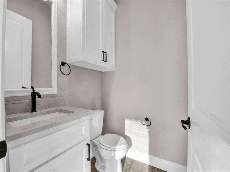 Bathroom with vanity, wood-type flooring, and toilet