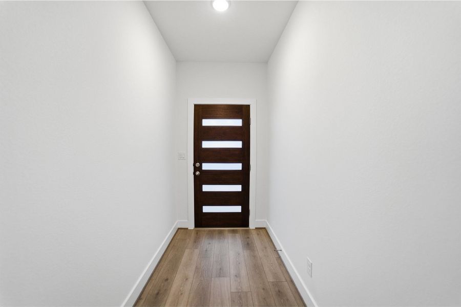 Doorway with baseboards and hardwood / wood-style floors