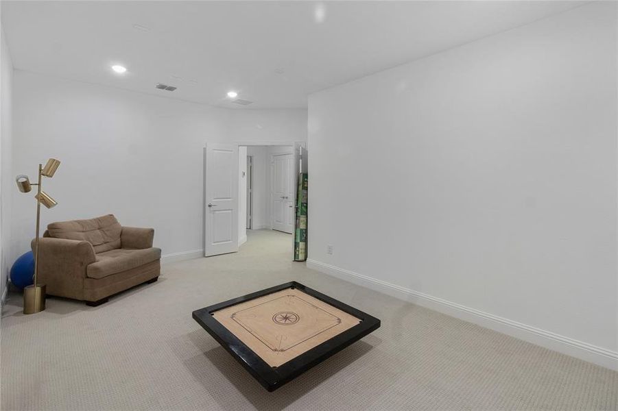 Spacious room featuring light-toned carpeting, recessed lighting, and white baseboards