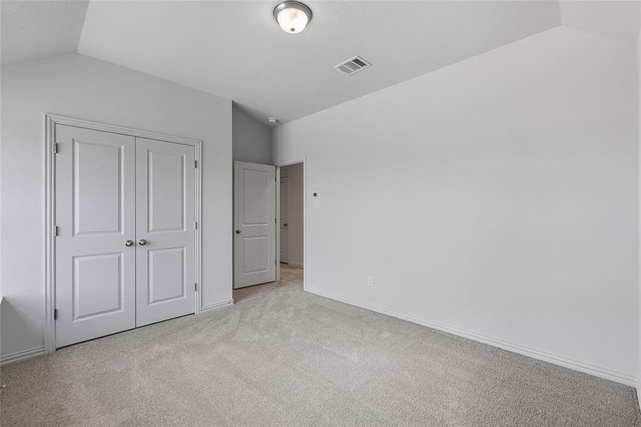Unfurnished bedroom with light carpet and a closet Unfurnished bedroom with light carpet and a closet
