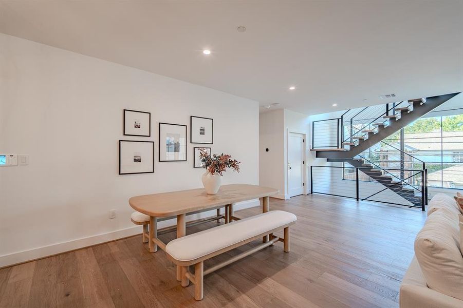 Dining area with light wood-type flooring, recessed lighting, and stairway Dining area with light wood-type flooring, recessed lighting, and stairway