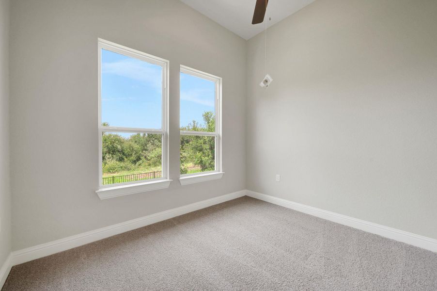 Carpeted spare room featuring baseboards and a ceiling fan Carpeted spare room featuring baseboards and a ceiling fan