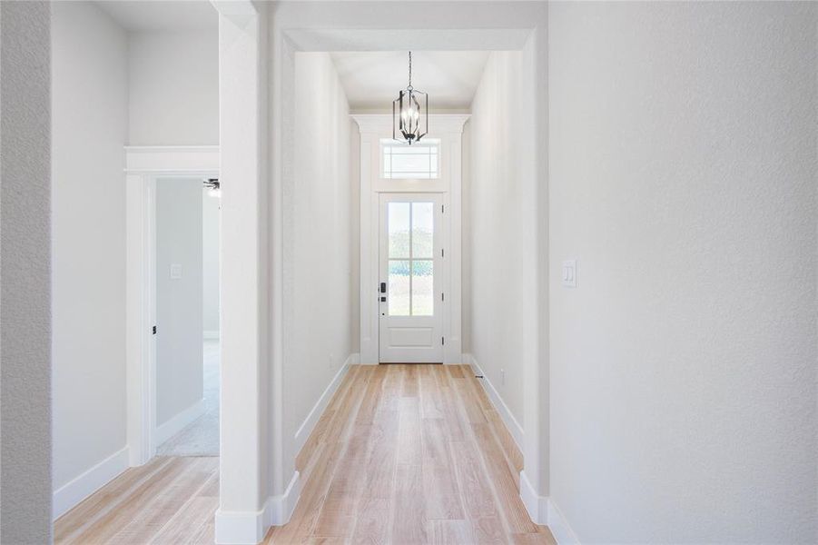 Doorway with a chandelier and light hardwood / wood-style floors