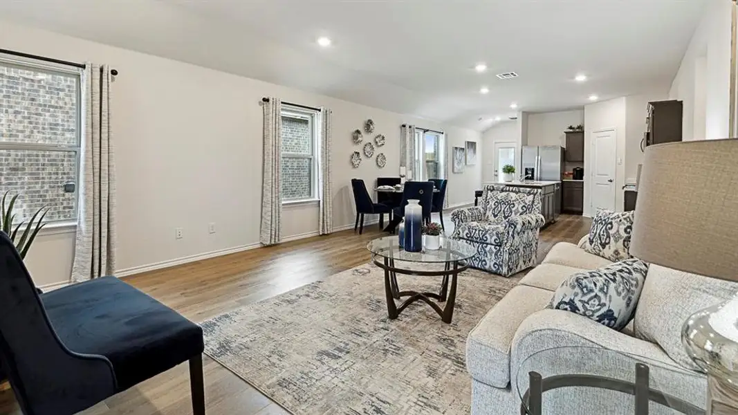 Living room with light wood-type flooring, recessed lighting, and vaulted ceiling Living room with light wood-type flooring, recessed lighting, and vaulted ceiling