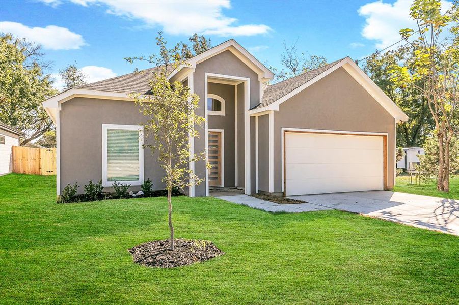 View of front of house featuring a garage and a front yard